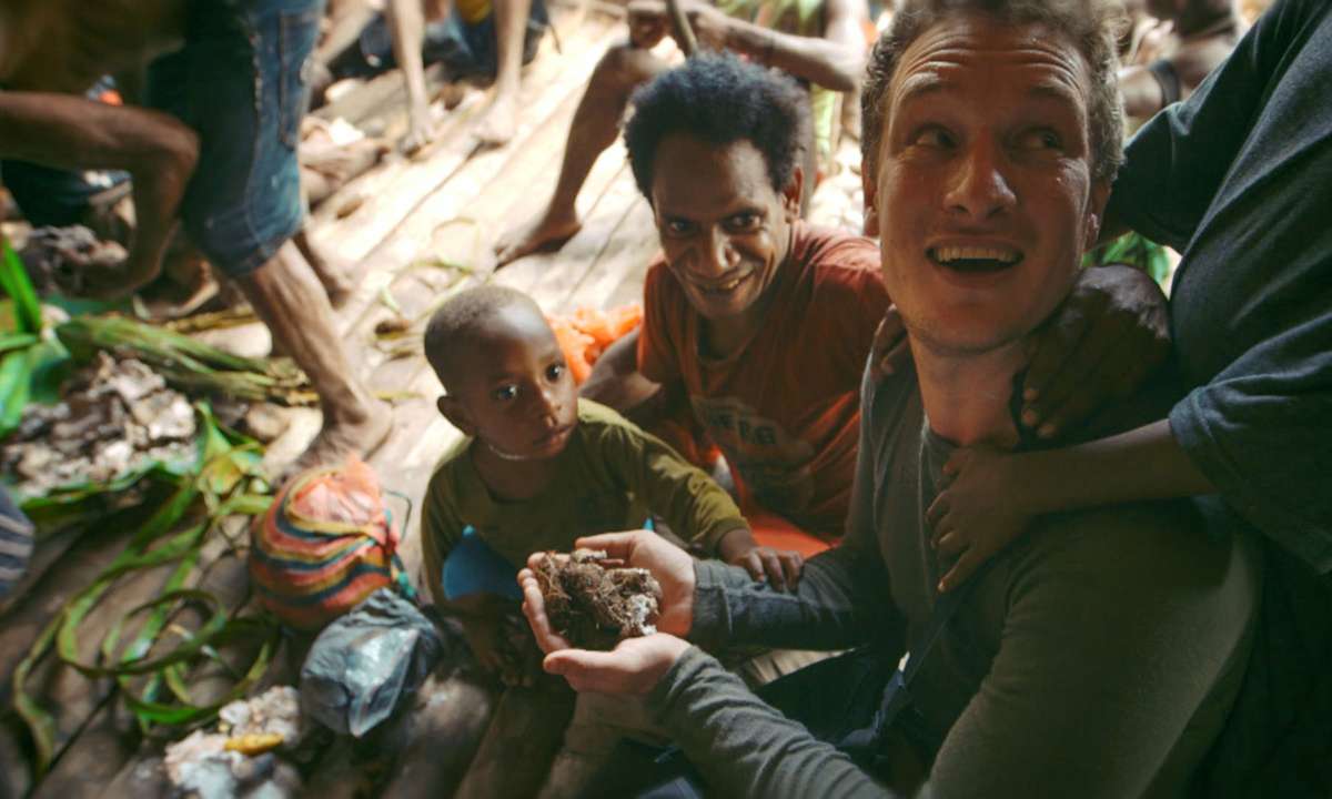 On arriving at a festival, Will is greeted by August and his sons with handfuls of fresh sago grubs (BBC/ KEO Films)