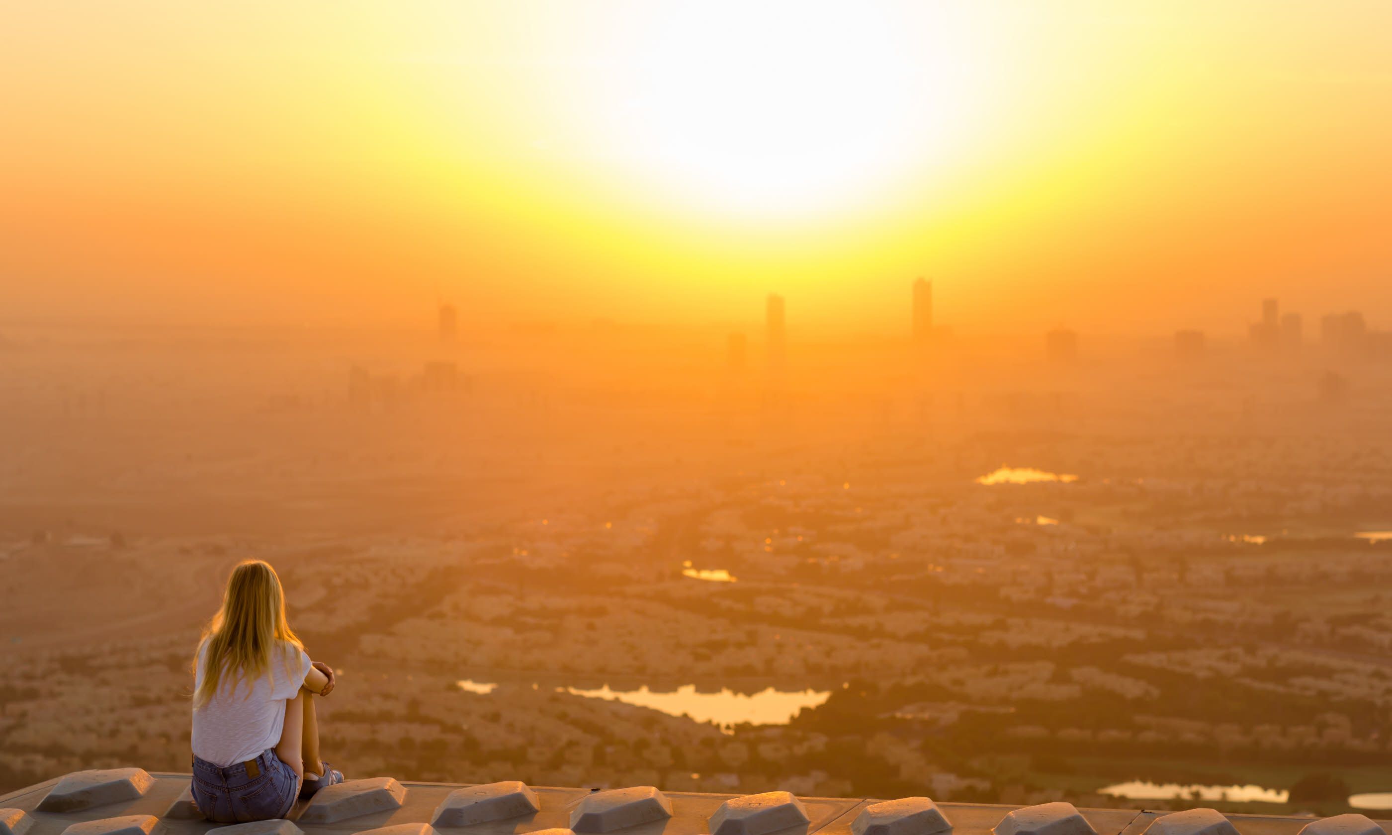 Woman overlooking the city at sunrise (Shutterstock)